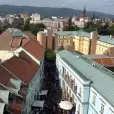 Pohled na Teplice s městskou zástavbou, věží v pozadí a horami na horizontu