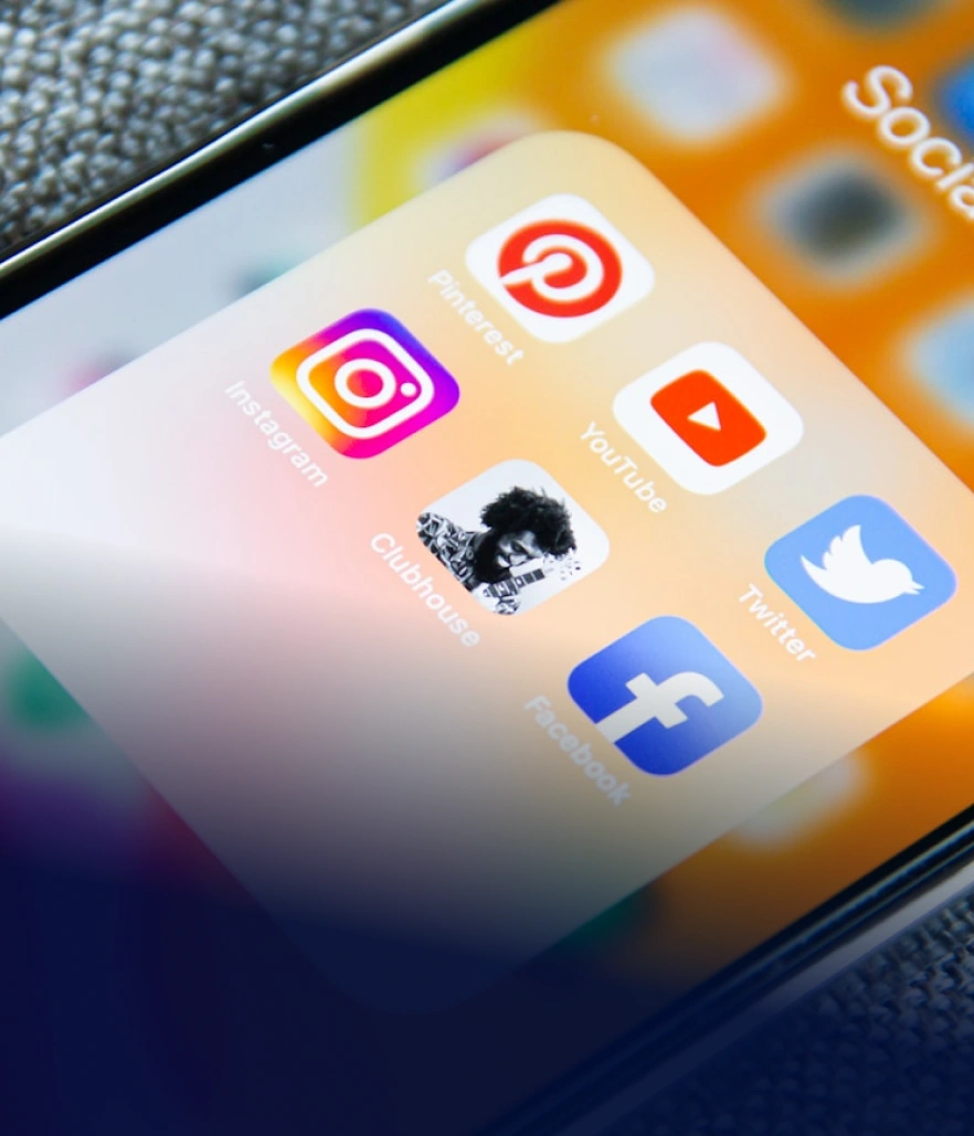 Detail displeje chytrého telefonu se složkou Sociální sítě a ikonami aplikací