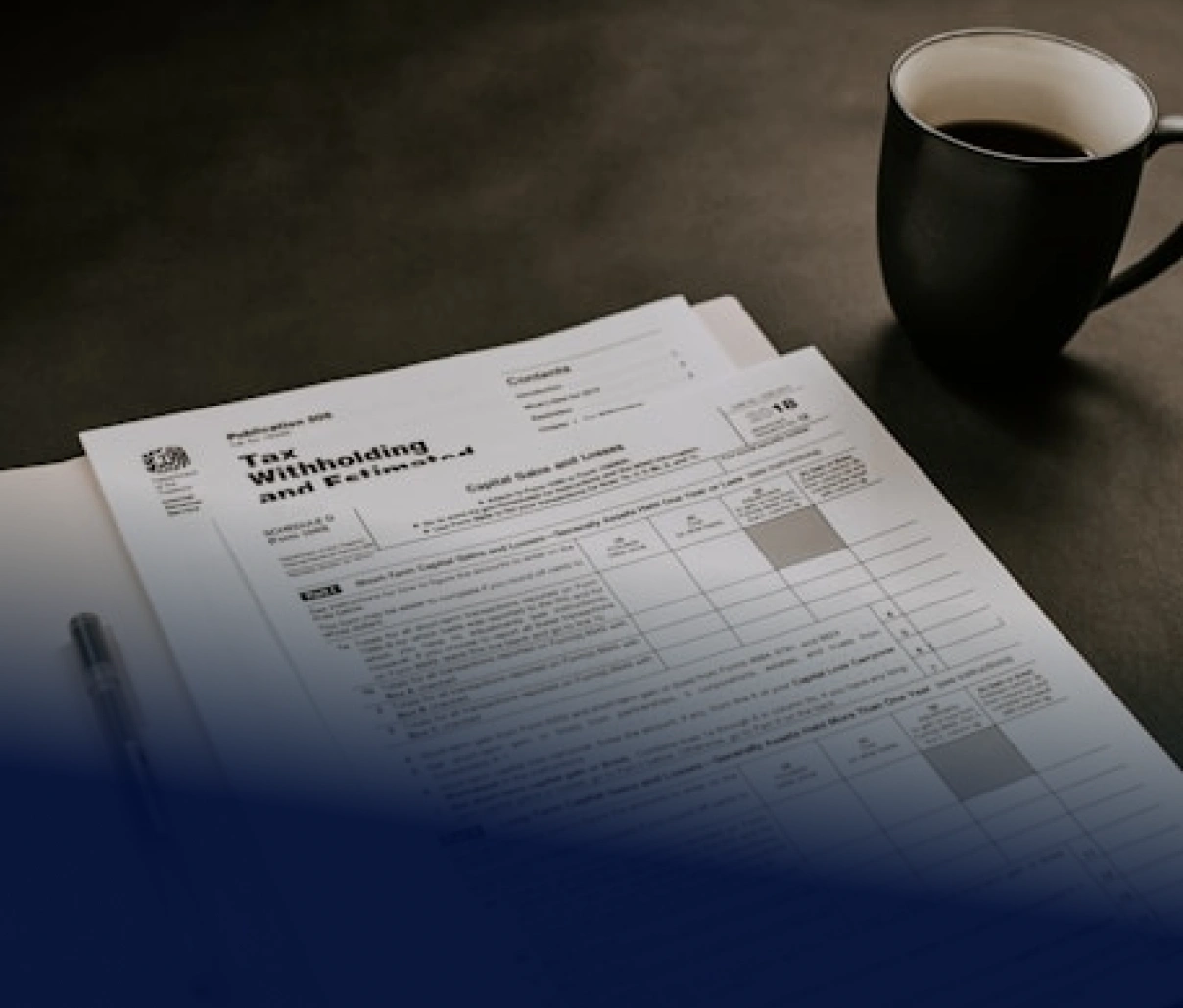 Formulář leží na stole vedle hrnku s kávou a propisky